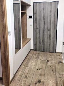 Bílé předsíňové skříně bez úchytek se zrcadlem vedle vstupních dveří