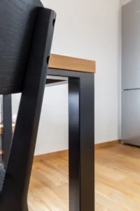 Detail černé stolové podnože a židle